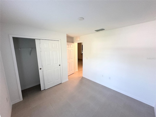 unfurnished bedroom with tile flooring and a closet