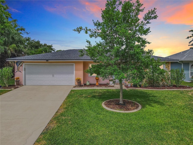 view of front of house with a garage and a lawn