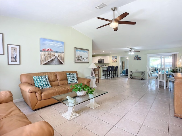 living room featuring light tile patterned floors, vaulted ceiling, and ceiling fan