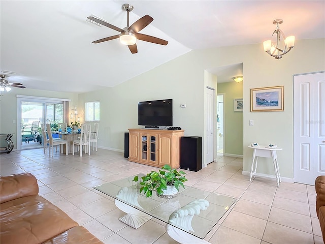 living room with light tile patterned flooring, lofted ceiling, and ceiling fan with notable chandelier