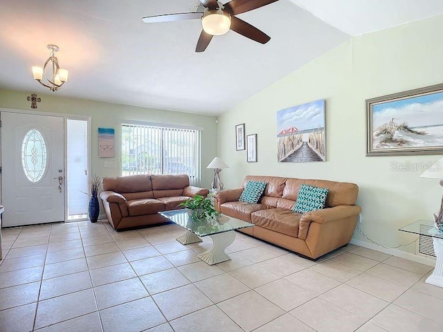 living room featuring ceiling fan with notable chandelier, lofted ceiling, and light tile patterned floors