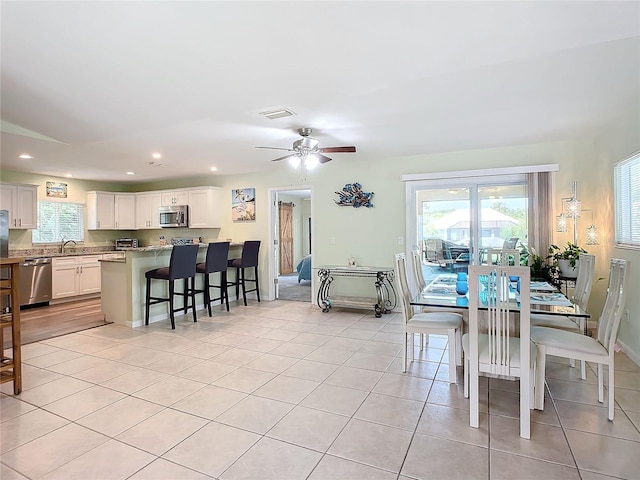 dining room with light tile patterned flooring, plenty of natural light, and sink