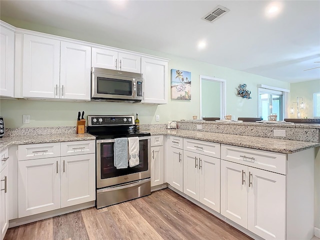 kitchen featuring white cabinetry, kitchen peninsula, stainless steel appliances, light stone countertops, and light hardwood / wood-style floors