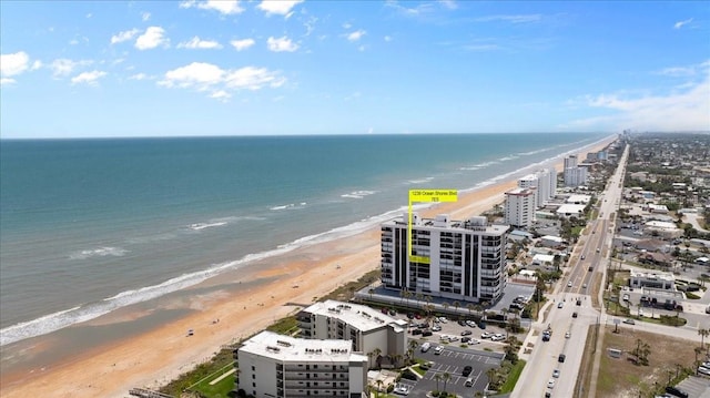 drone / aerial view featuring a water view and a view of the beach