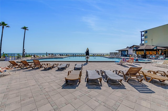 view of terrace with a community pool and a water view