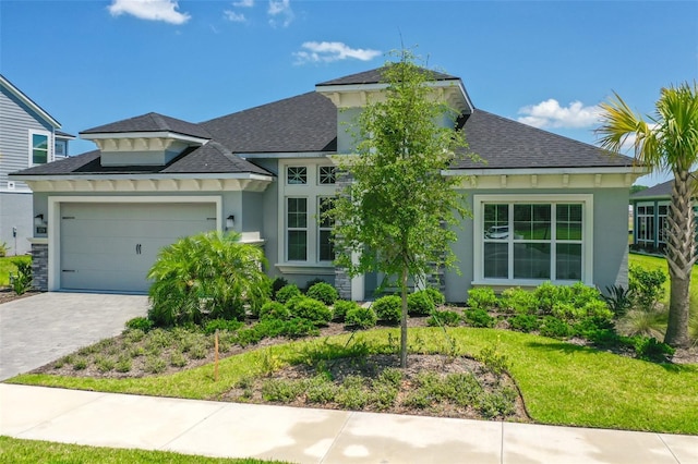 view of front of house featuring a garage and a front lawn