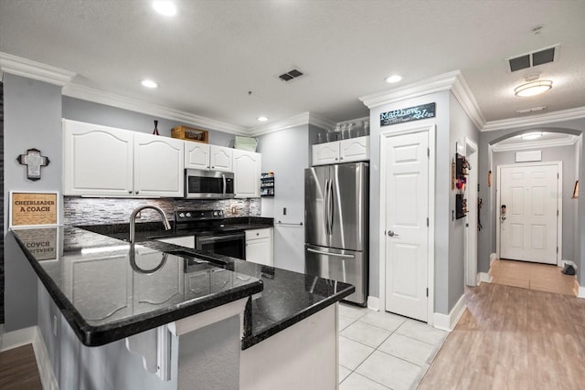 kitchen with kitchen peninsula, light tile patterned floors, and appliances with stainless steel finishes