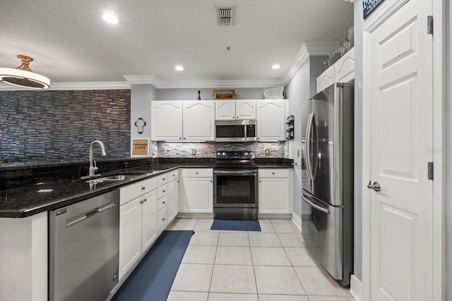 kitchen featuring tasteful backsplash, sink, white cabinets, and appliances with stainless steel finishes