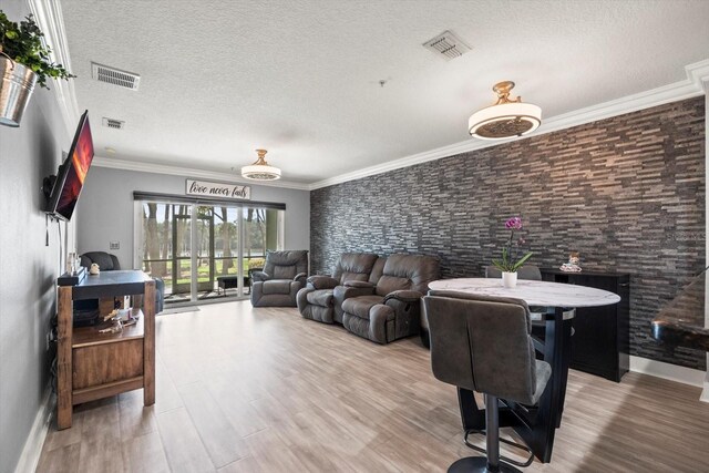 living room featuring ornamental molding, a textured ceiling, and hardwood / wood-style flooring