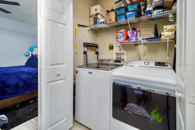 washroom featuring washing machine and dryer, ceiling fan, and a textured ceiling