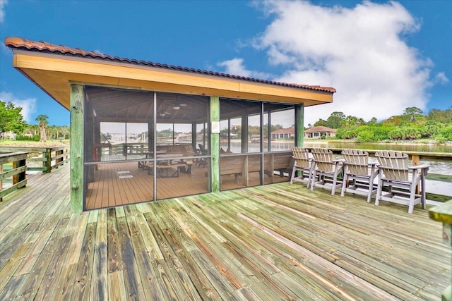 wooden deck featuring a sunroom and a water view