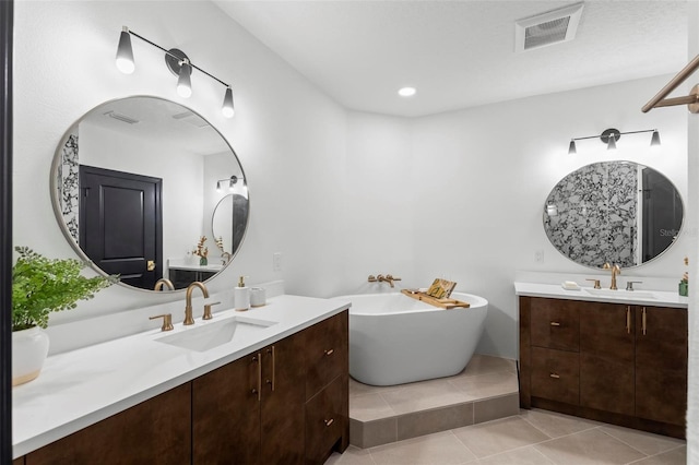 bathroom with vanity, a bath, and tile patterned floors