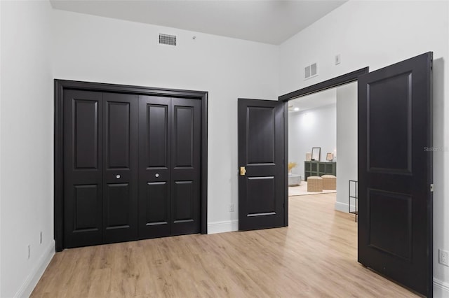 unfurnished bedroom with a closet and light hardwood / wood-style floors