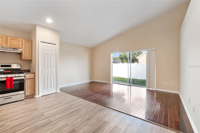 kitchen featuring high vaulted ceiling, light hardwood / wood-style flooring, light brown cabinets, and stainless steel range with gas cooktop