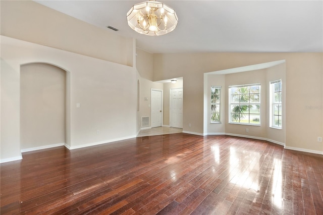 unfurnished room with hardwood / wood-style floors, vaulted ceiling, and a chandelier