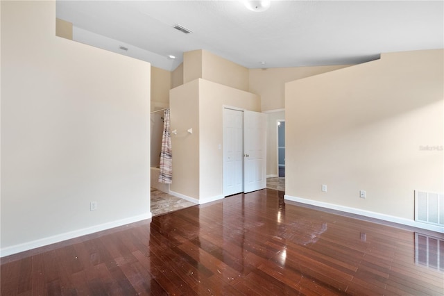 unfurnished room featuring high vaulted ceiling and wood-type flooring