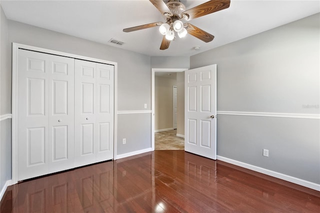 unfurnished bedroom featuring wood-type flooring, ceiling fan, and a closet