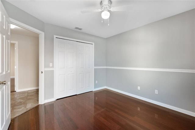 unfurnished bedroom with a closet, ceiling fan, and dark hardwood / wood-style floors