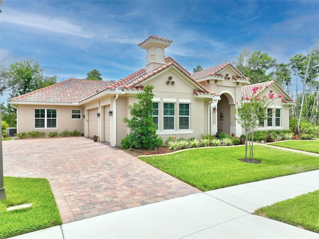 mediterranean / spanish-style home with a front yard and a garage