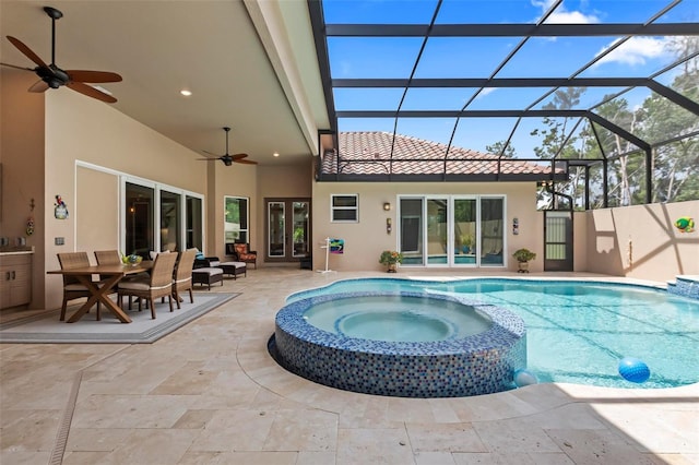 view of swimming pool with a patio, ceiling fan, an in ground hot tub, and glass enclosure