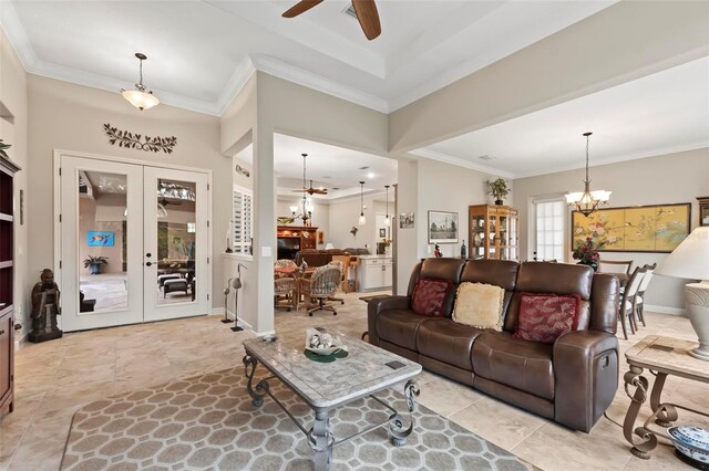 living room with ceiling fan with notable chandelier, ornamental molding, and french doors