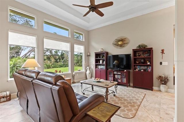 living room with a tray ceiling, ornamental molding, and ceiling fan