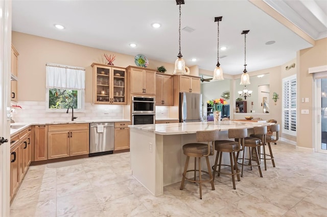 kitchen featuring tasteful backsplash, a center island, hanging light fixtures, a kitchen breakfast bar, and stainless steel appliances