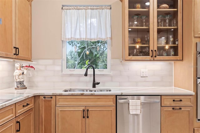 kitchen featuring tasteful backsplash, sink, light stone counters, and stainless steel dishwasher