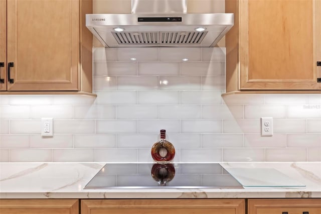 kitchen featuring tasteful backsplash, black electric stovetop, extractor fan, and light stone counters