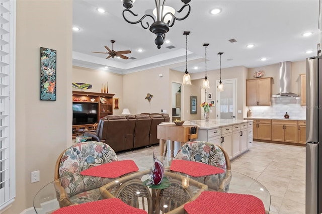 dining room with a raised ceiling and ceiling fan