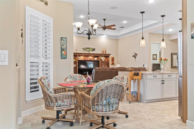 dining area with a notable chandelier and a tray ceiling