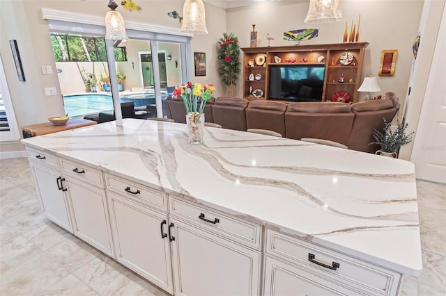 kitchen featuring white cabinetry, hanging light fixtures, and light stone countertops