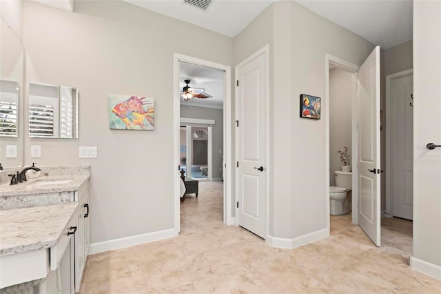 bathroom featuring vanity, ceiling fan, and toilet