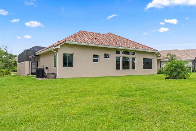 rear view of house featuring cooling unit, a yard, and a lanai