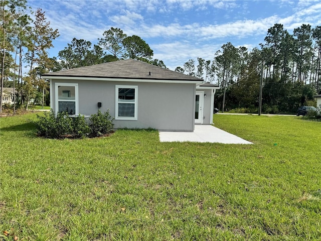 back of house featuring a patio area, stucco siding, and a lawn