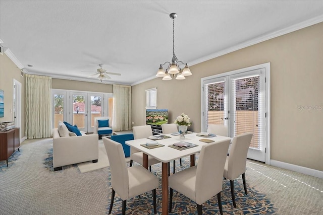 dining room with ornamental molding, light carpet, french doors, and ceiling fan with notable chandelier