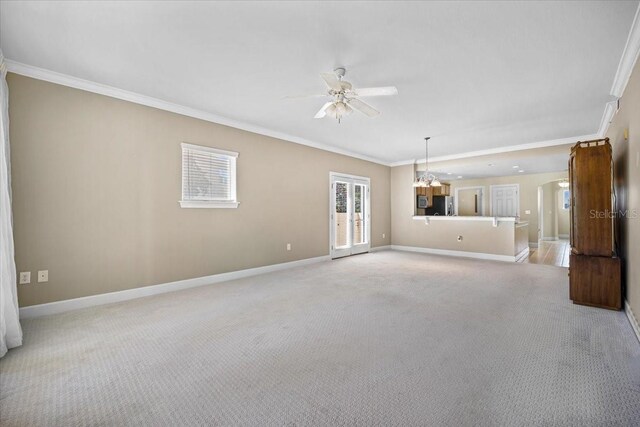 unfurnished living room featuring light carpet, baseboards, ornamental molding, and ceiling fan with notable chandelier