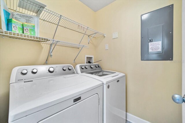 washroom featuring laundry area, separate washer and dryer, electric panel, and baseboards