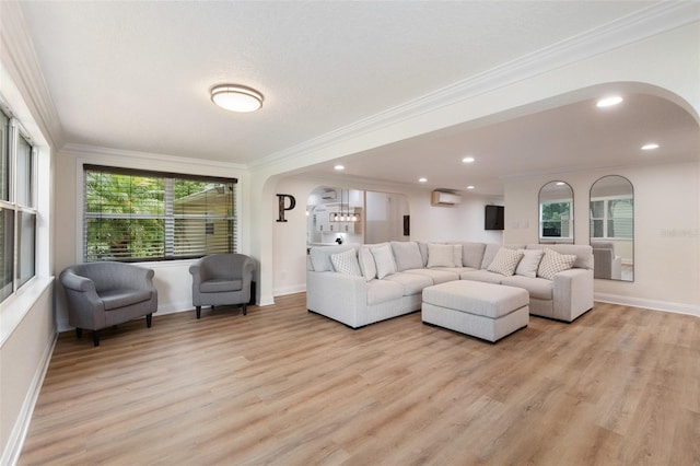 living room with ornamental molding, light hardwood / wood-style floors, and an AC wall unit