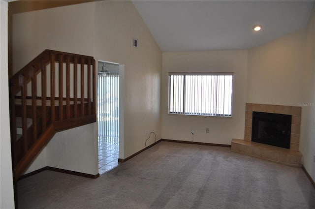 unfurnished living room featuring vaulted ceiling, carpet, and a tiled fireplace