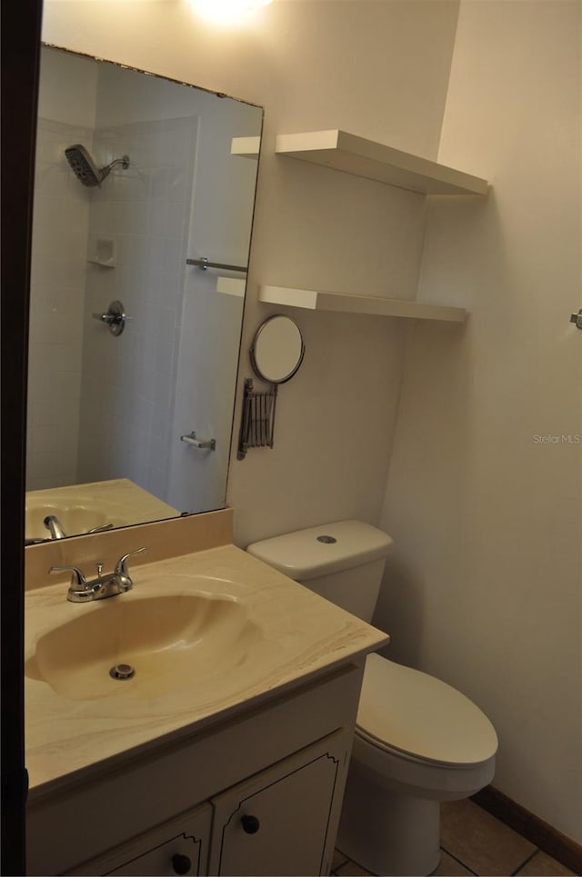 bathroom featuring tile flooring, toilet, and vanity