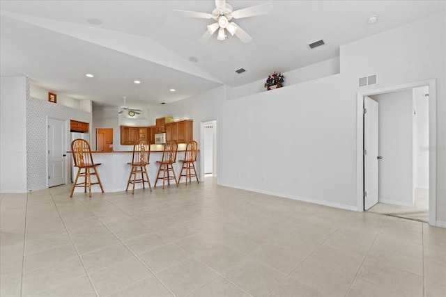 unfurnished living room featuring ceiling fan, lofted ceiling, and light tile patterned floors