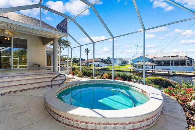 view of pool featuring an in ground hot tub, a water view, and a lanai