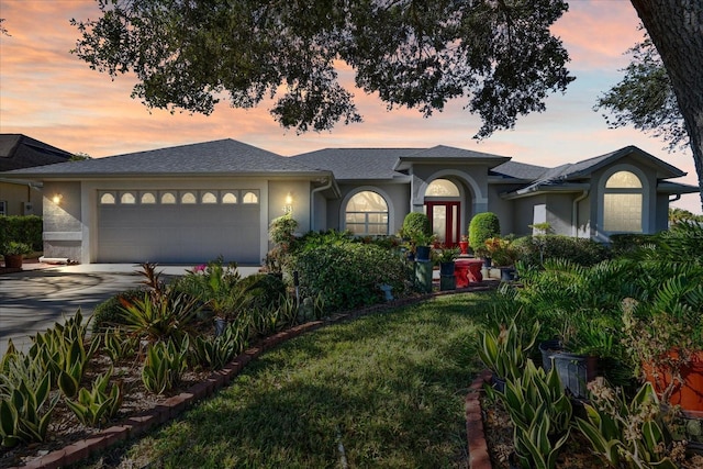 view of front of property with a garage and a lawn