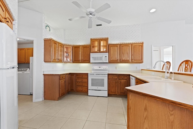 kitchen featuring white appliances, sink, ceiling fan, light tile patterned flooring, and kitchen peninsula