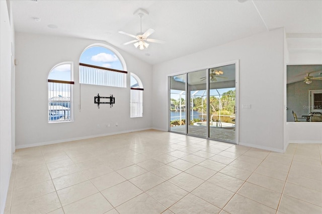 tiled spare room with ceiling fan and vaulted ceiling