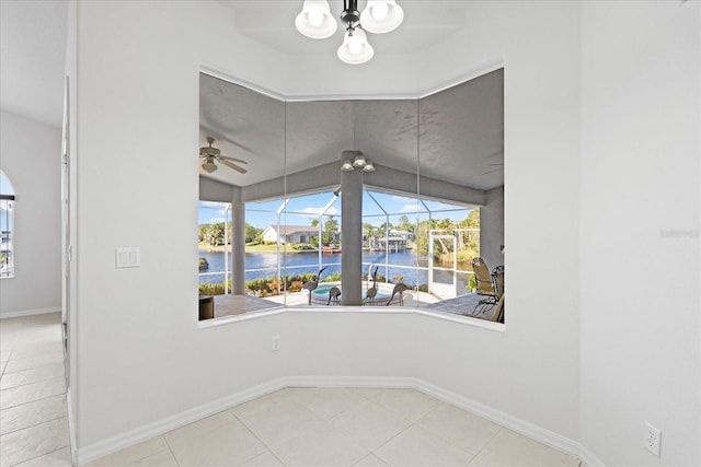 unfurnished room with ceiling fan, tile patterned flooring, and a water view