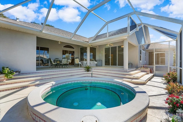 view of pool featuring glass enclosure, a patio area, and an in ground hot tub