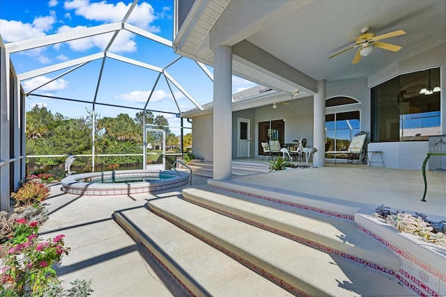 view of patio featuring a lanai, ceiling fan, and an in ground hot tub