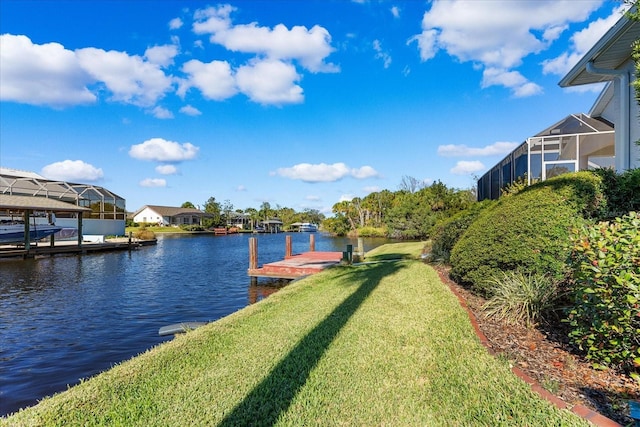 view of dock featuring a yard, a water view, and glass enclosure